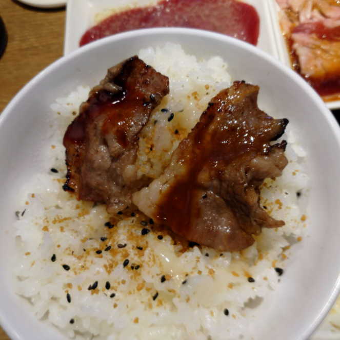 ご飯に肉を乗せている様子